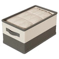 Gray and beige fabric storage bin with a clear top panel, side handle, and folded bedding inside.