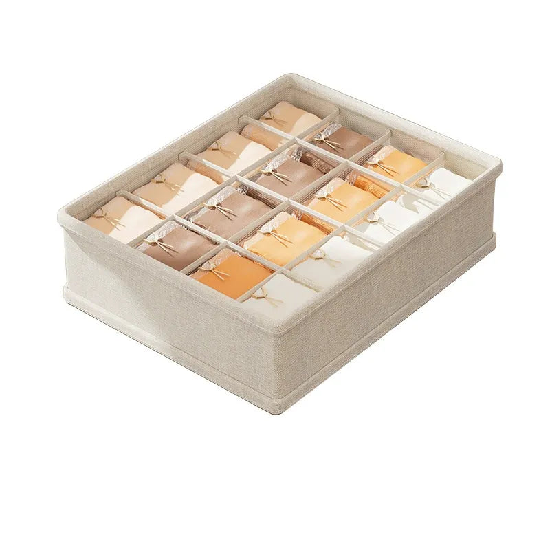 Beige fabric drawer organizer with multiple compartments holding neatly folded underwear.