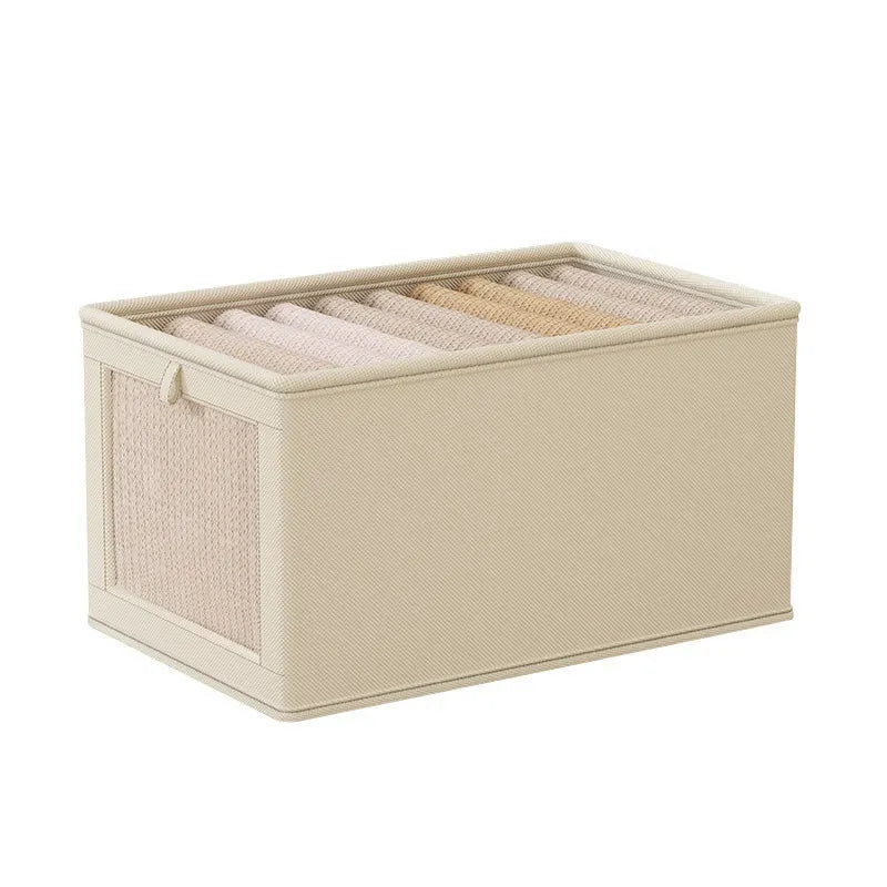 Beige fabric storage box with a zippered mesh side panel, neatly holding folded clothing.